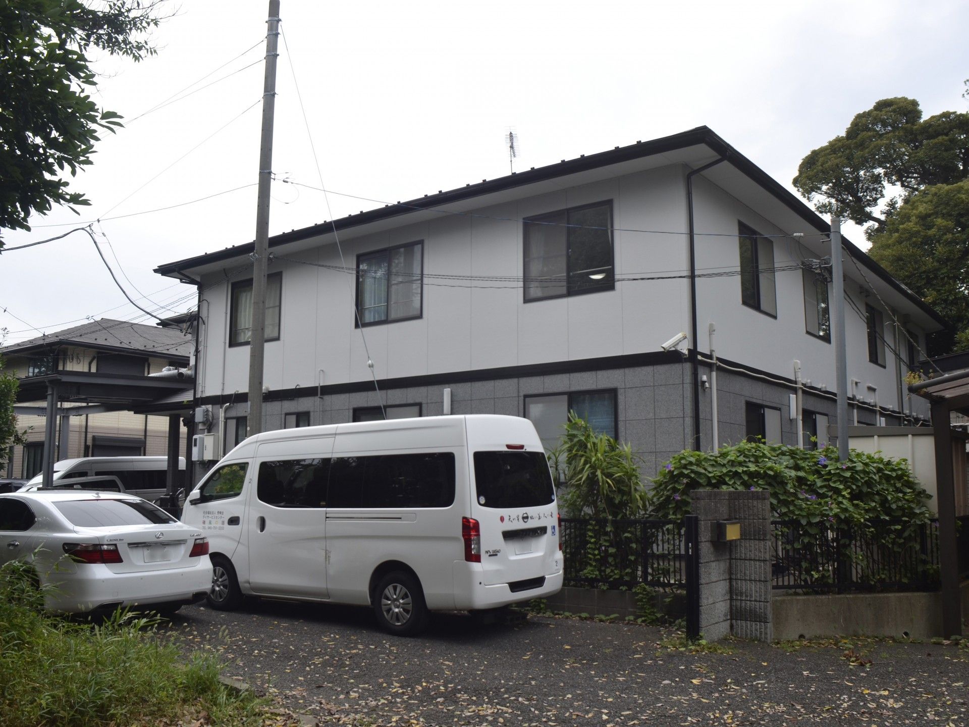 白い車が停まる建物外観