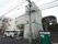 壁にブルーのラインが入った３階建てのホームである。道路側から階段を登る入口もある。サイドにホーム名が記された車が停められる。