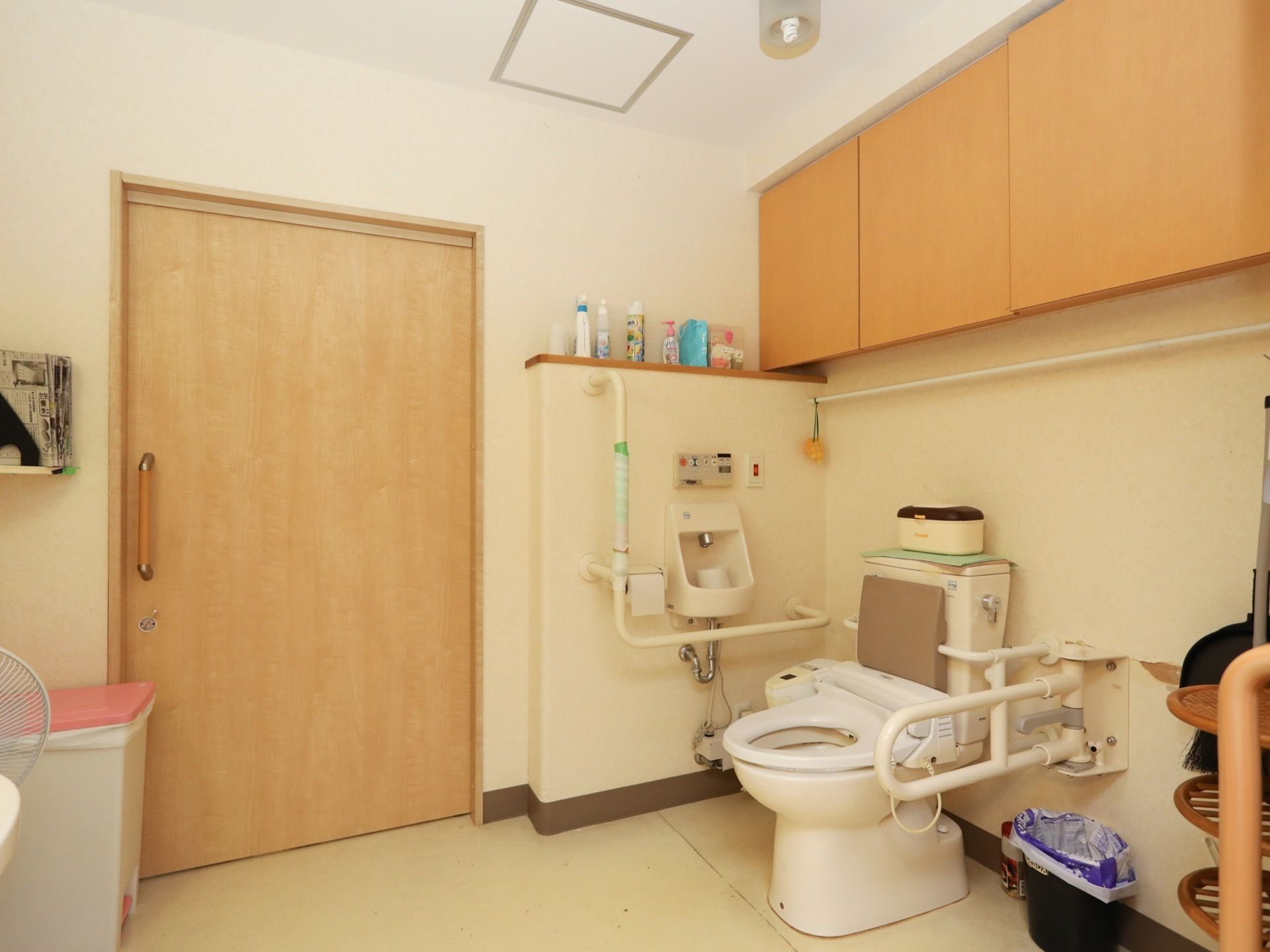 引き戸式の扉が備え付けられた、洋式トイレである。広く、開放感がある。可動式、Ｌ字型の手すりがある。