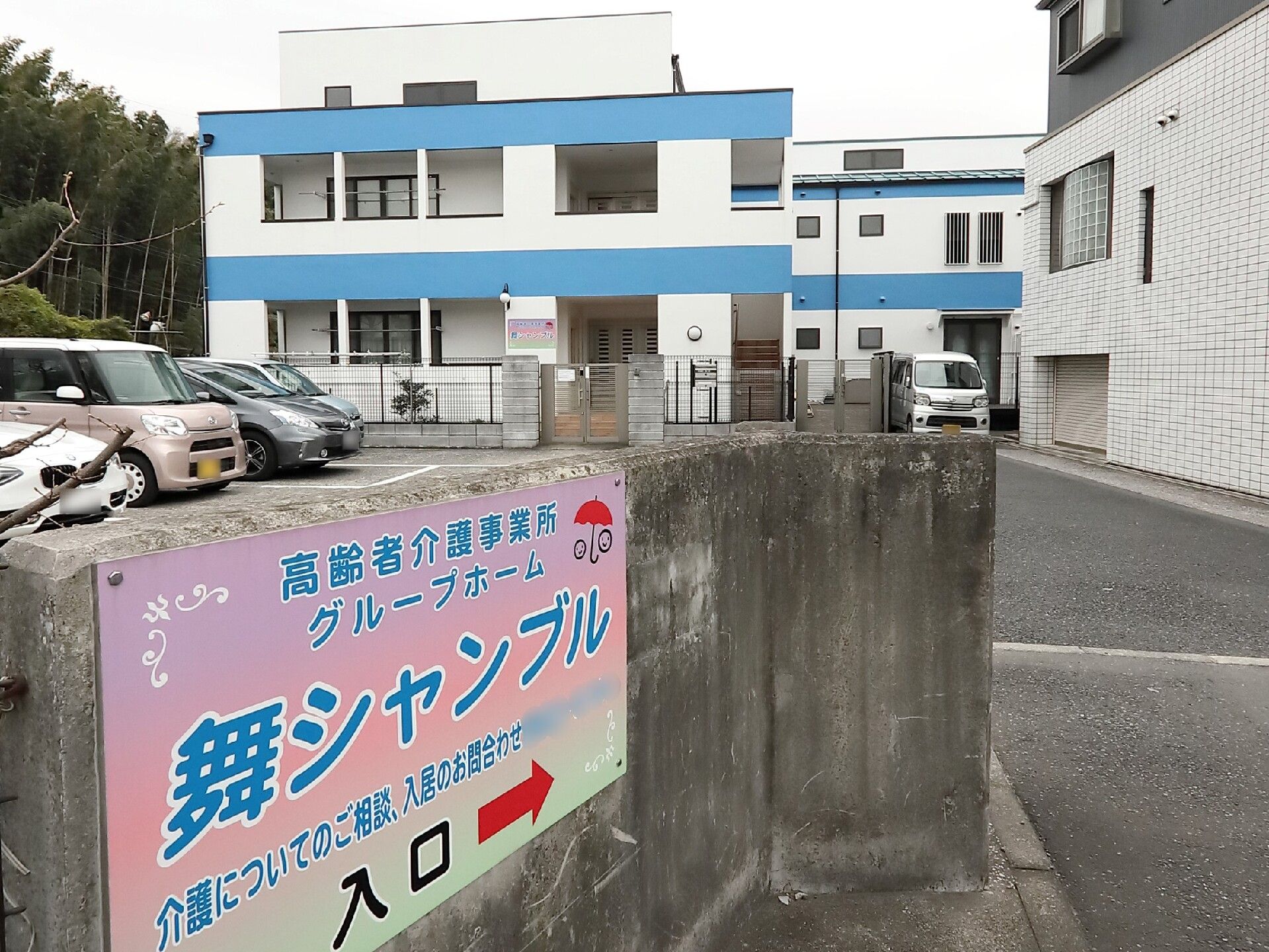 フェンスで囲まれた防犯性の高い施設外観と施設駐車場