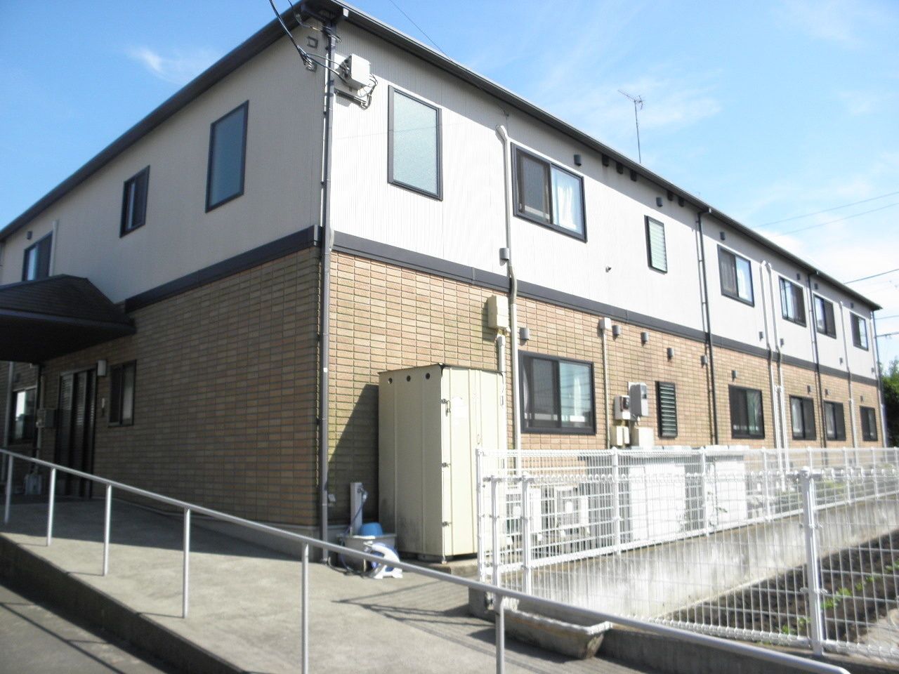 ２階建ての建物は横に長く、日当たりのいい場所に建っている。手すり付きのスロープもある。