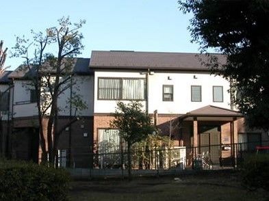 家庭的な雰囲気の2階建ての家。玄関には屋根が付き、庭もある。