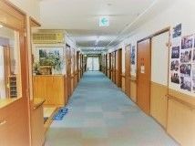 施設内の廊下を写した写真。下側が木星になっている廊下の壁。両側に個室のドアがある