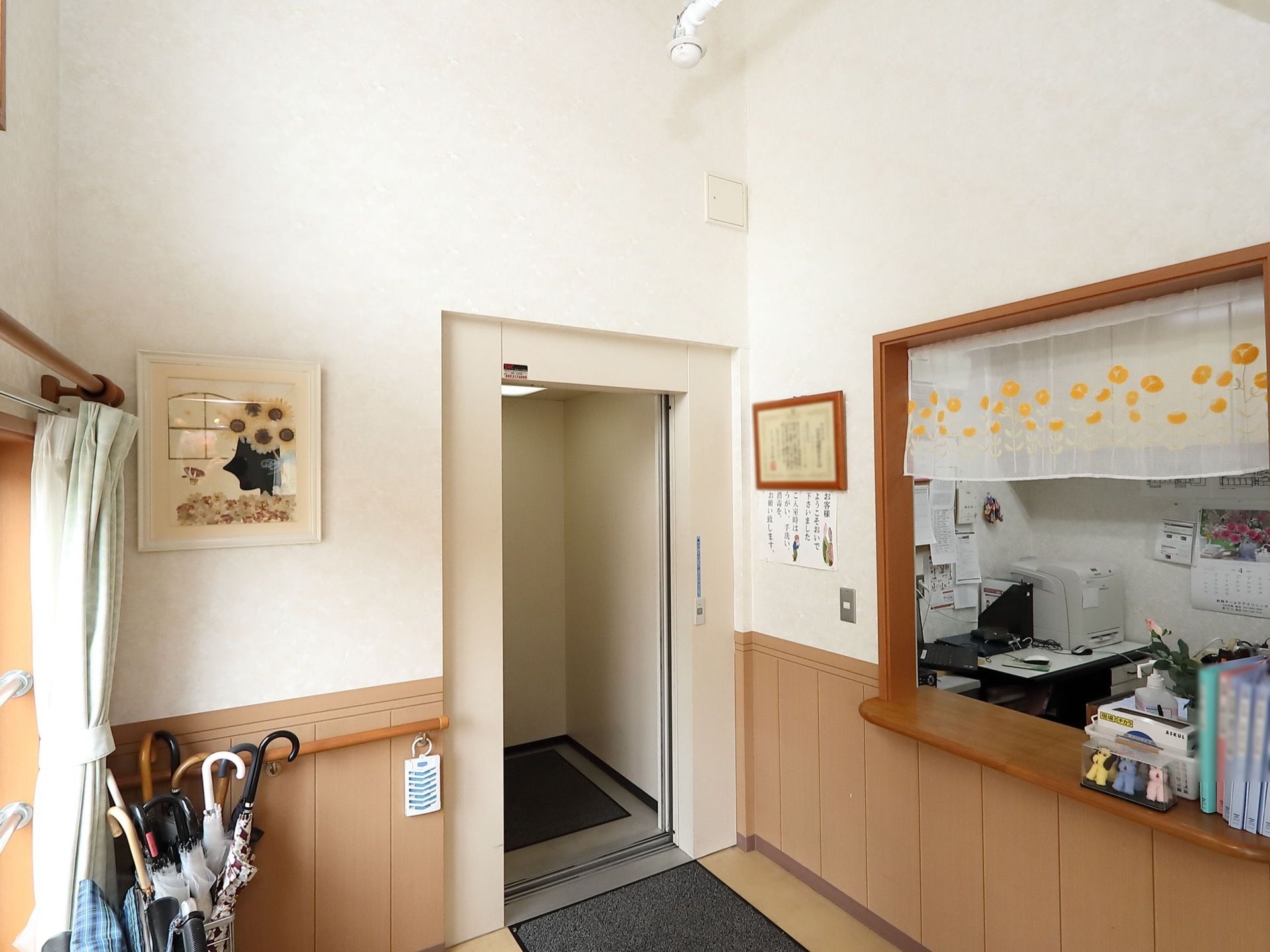 エレベーターの内部とホールの床面に滑り止めマットが敷いてある。右側のカウンターには扉がついていない。