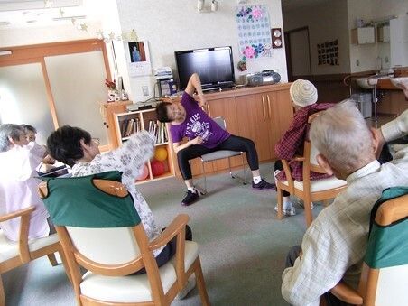 腕を動かして体操をする入居者の様子