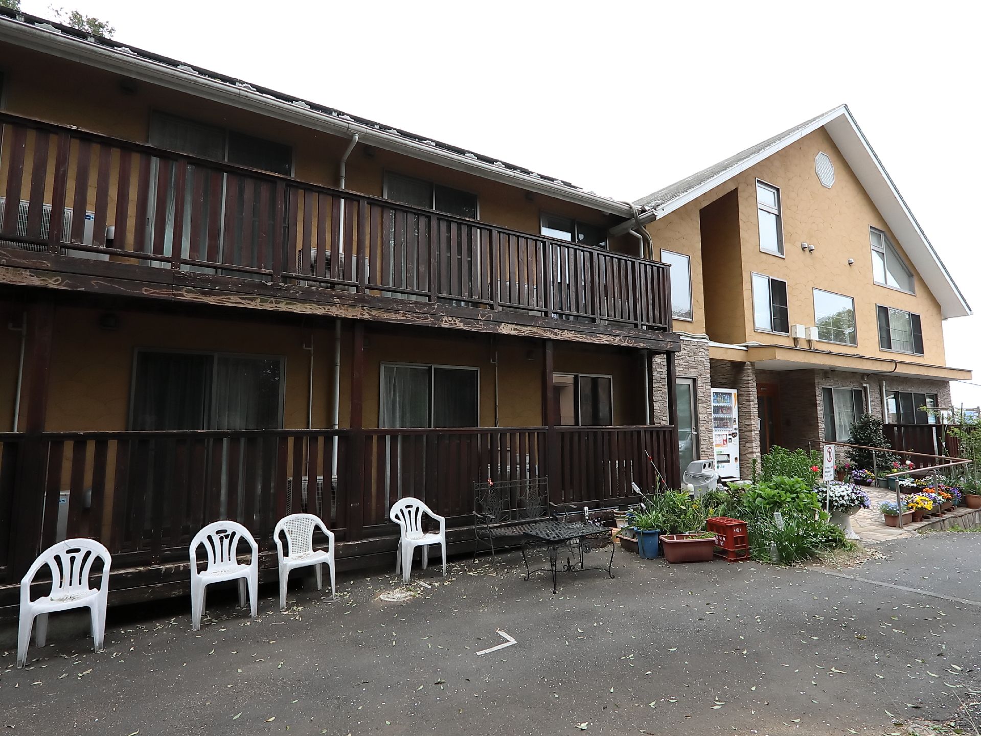 二つに並んだこげ茶色の古い建物とベージュ色の新しい建物
