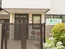 鉄骨造のグループホーム朋友のエントランス。２階建ての住宅風の建物の全景が写っている