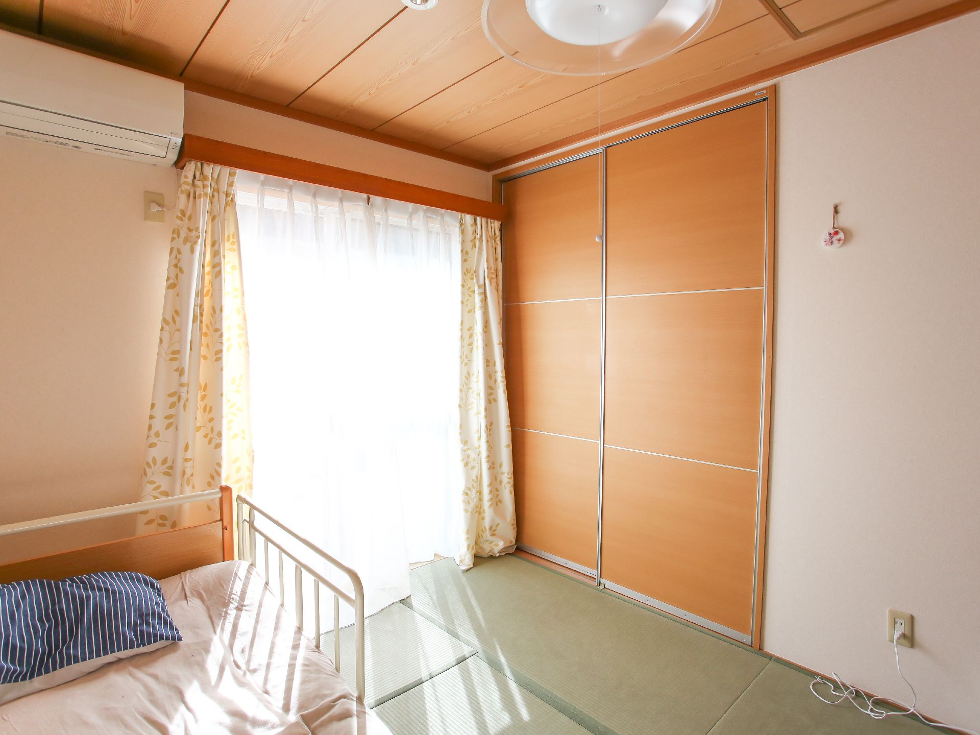 なにかに笑顔で手を振っている女性とその人の方を持ち同じ方向に笑顔を見せているスタッフ