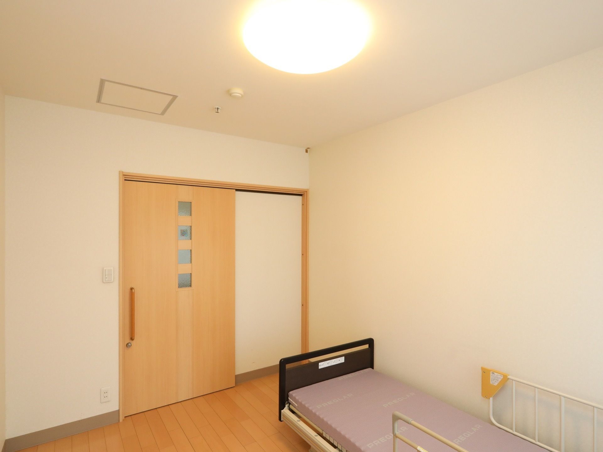 広々とした個室である。引き戸式タイプの扉に、明かり窓が備えられている。天井には丸型の照明がある。