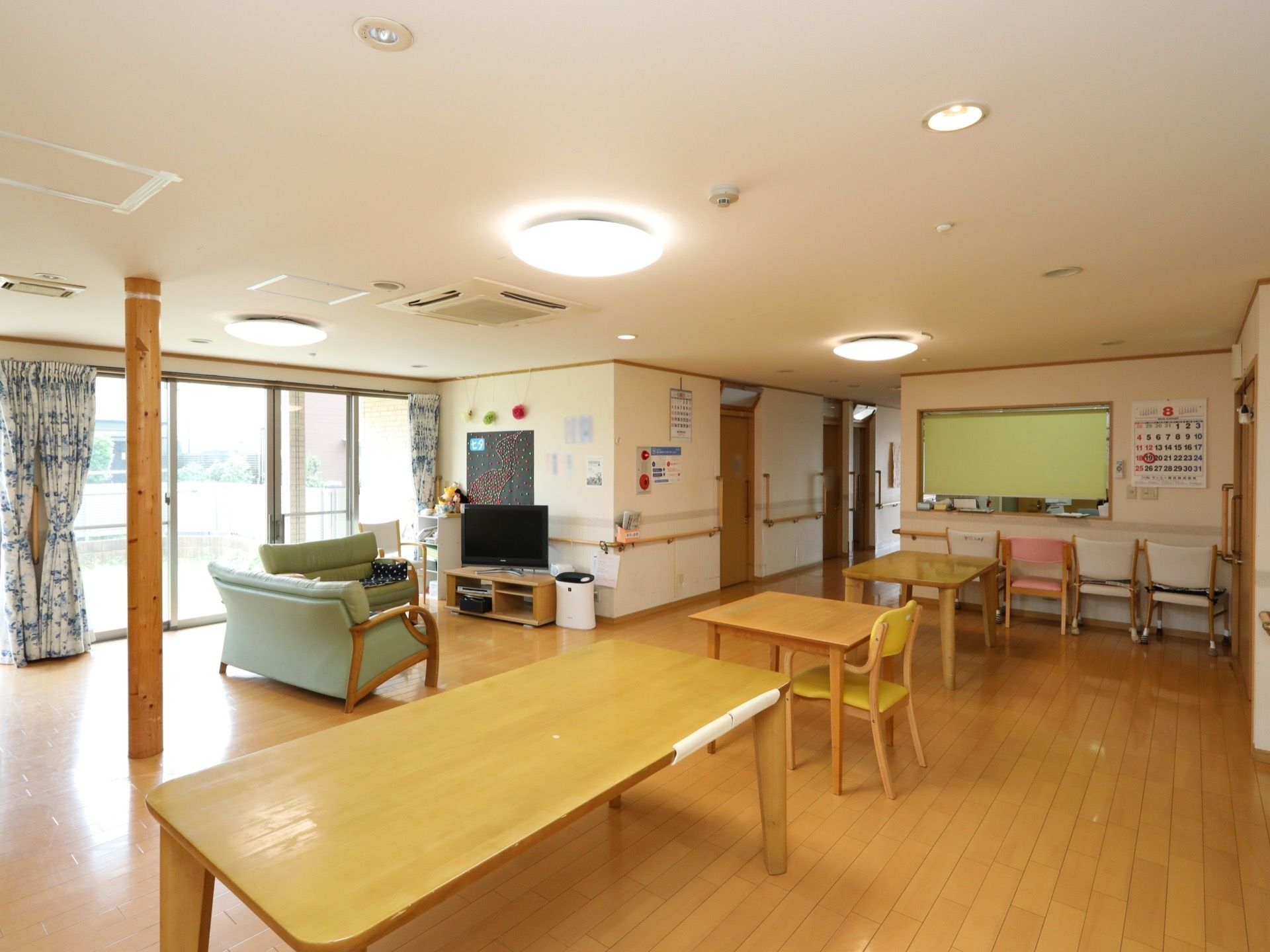木のあたたかい雰囲気がただよう、共有空間である。窓の近くにはテレビとソファを完備。広さにゆとりのある設計である。