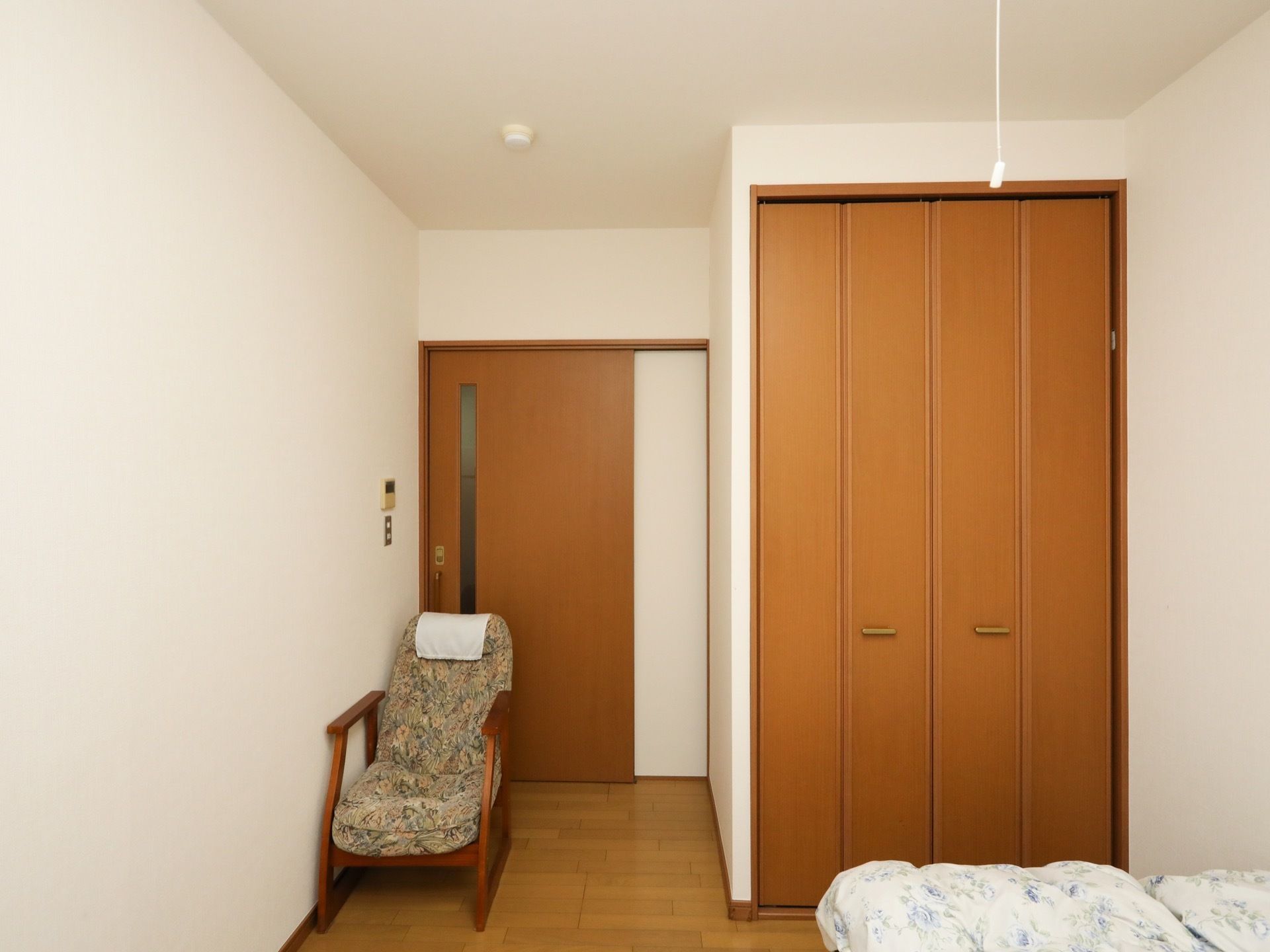 居室入口扉は、細長いスリットガラスが入った引き戸である。入口近くに大きな背もたれがついた椅子がある。