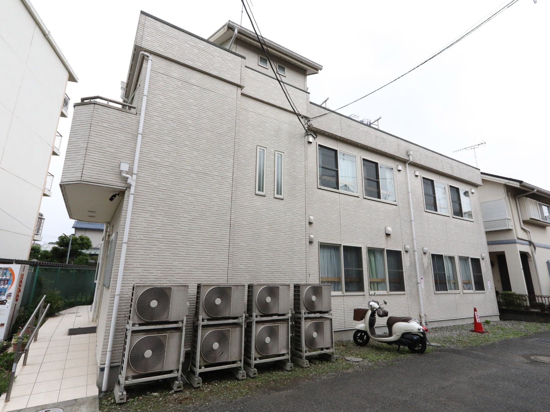 ２階建ての施設である。屋上が完備されており、洗濯の物干し竿が設置されている。建物の前に８台のエアコン室外機と１台のスクーターがある。