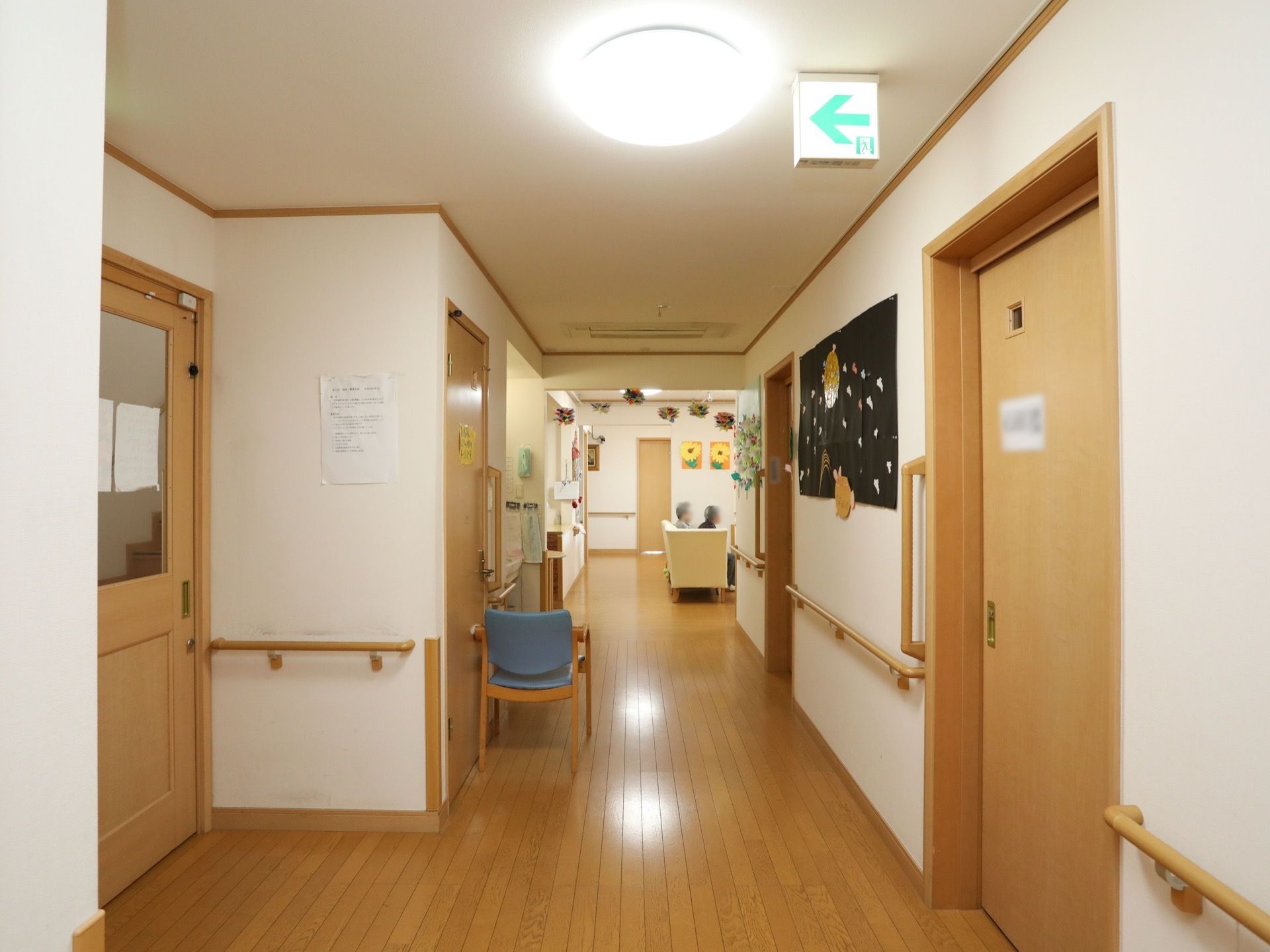 広々とした通路に季節ならではの作品が飾られている。床はフローリングで、壁には手すりがある。