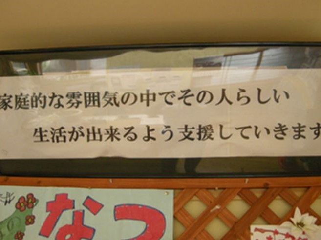 入居者様の憩いの場には、施設の運営理念が書かれた横断幕が掲げられている。スタッフ一同はいつも心得て介護に専念している。