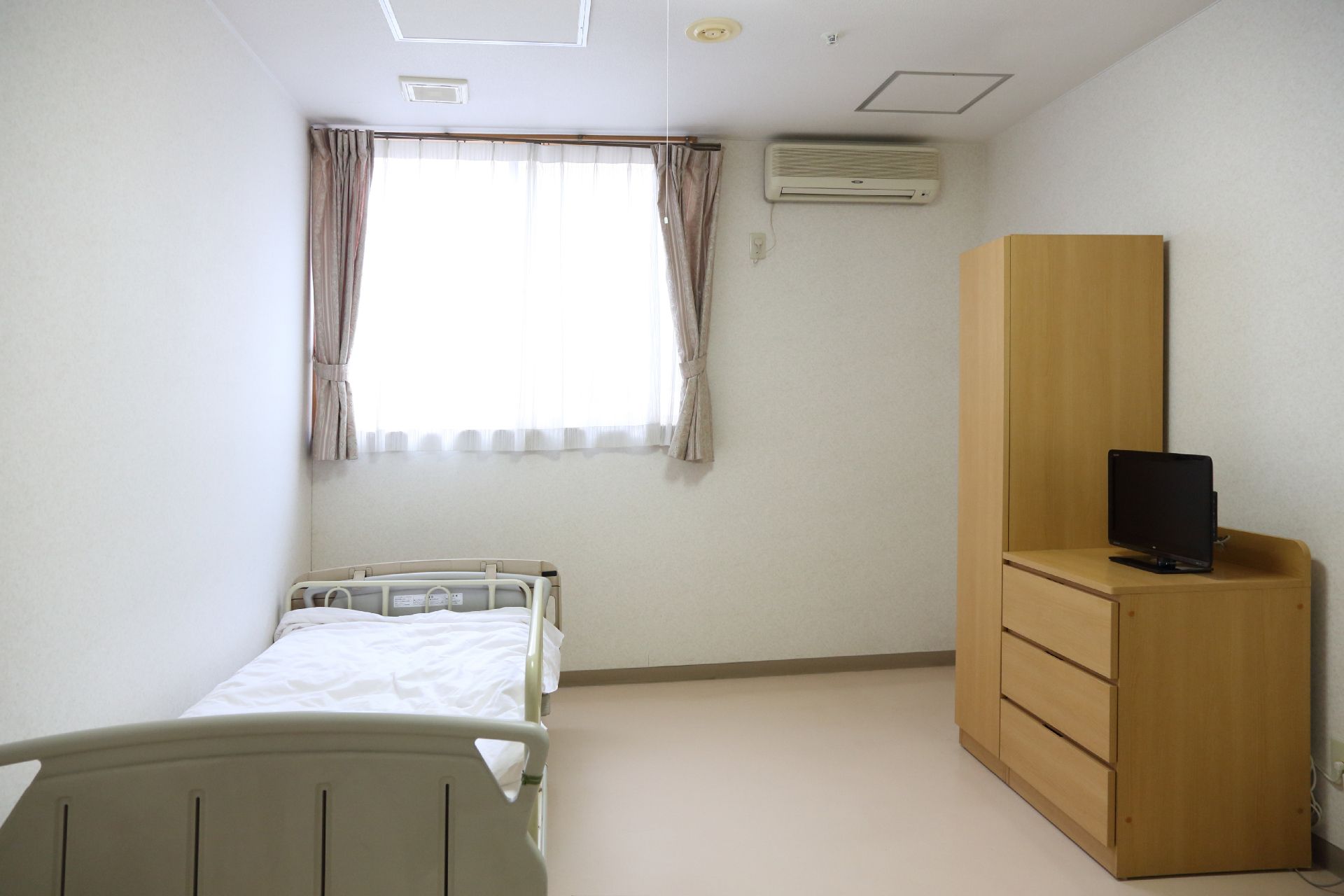 ベッドやチェストが設置された居室