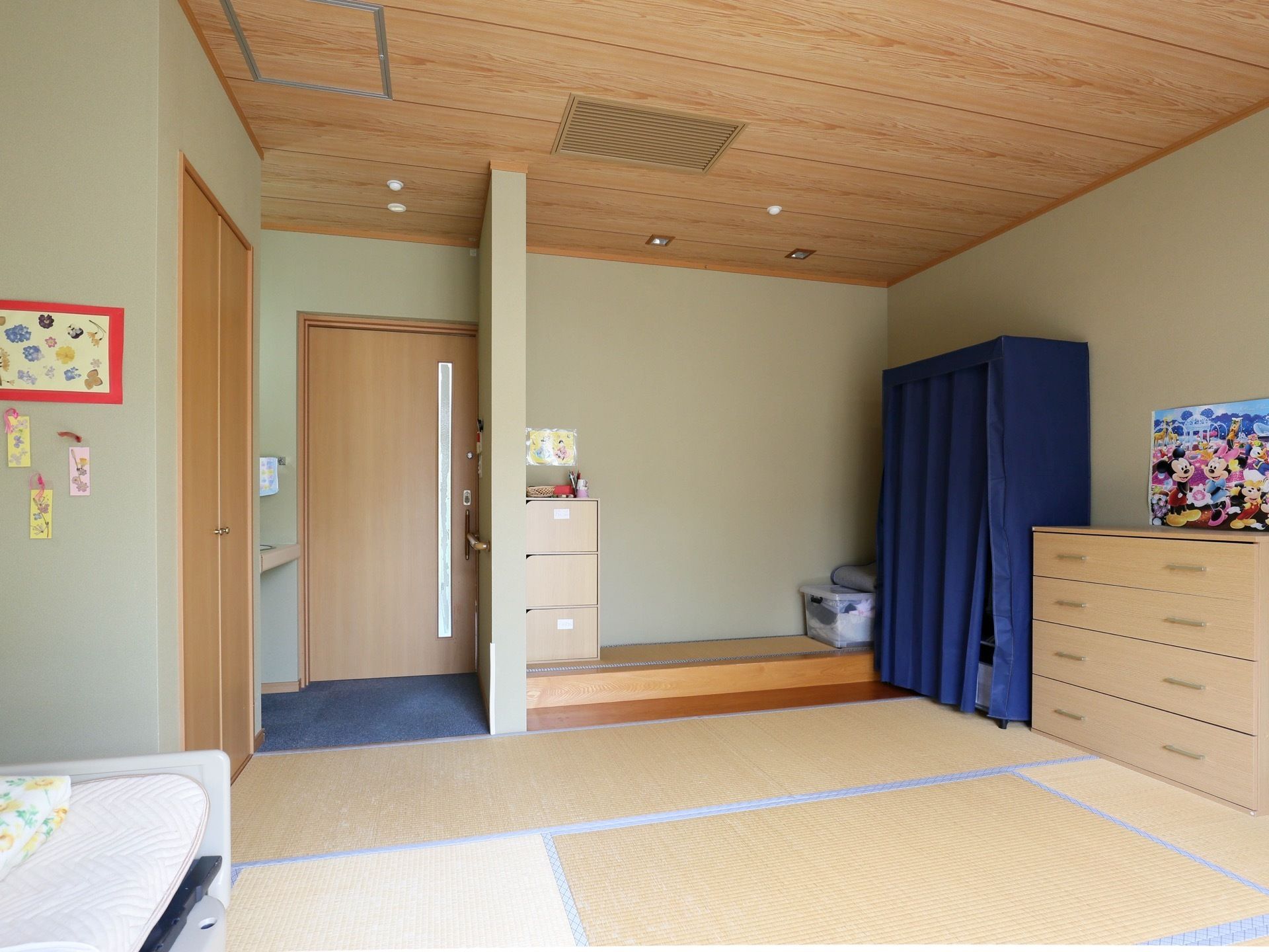 居室は広い和室で、畳が敷かれている。ベッド、洋服ダンス、クローゼットなどがある。ドアはスライドタイプを採用。