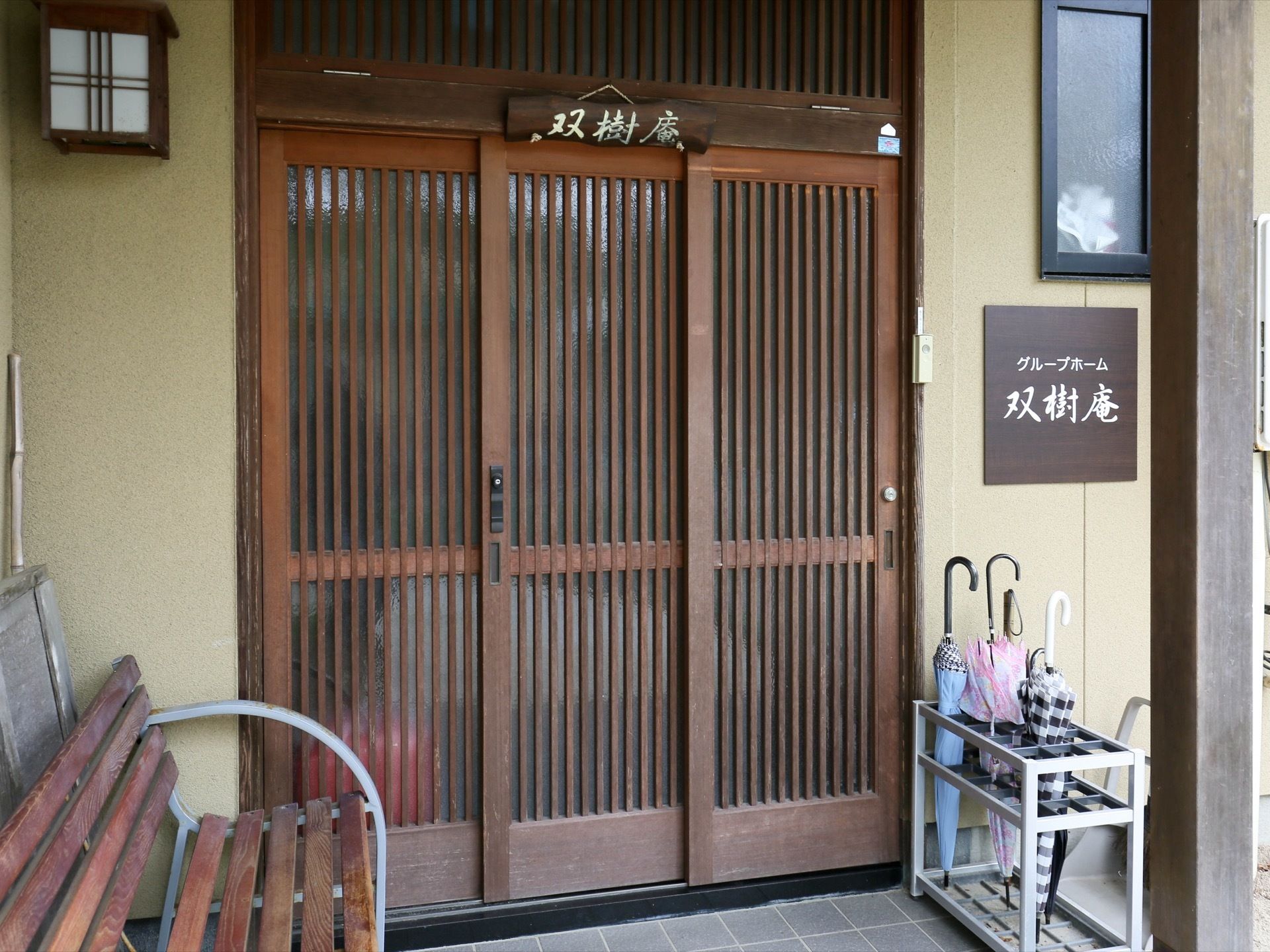 施設の入口ドアは濃い茶色で、スライド式である。ドアの上部と、隣の壁には施設名のプレートが掲げてある。