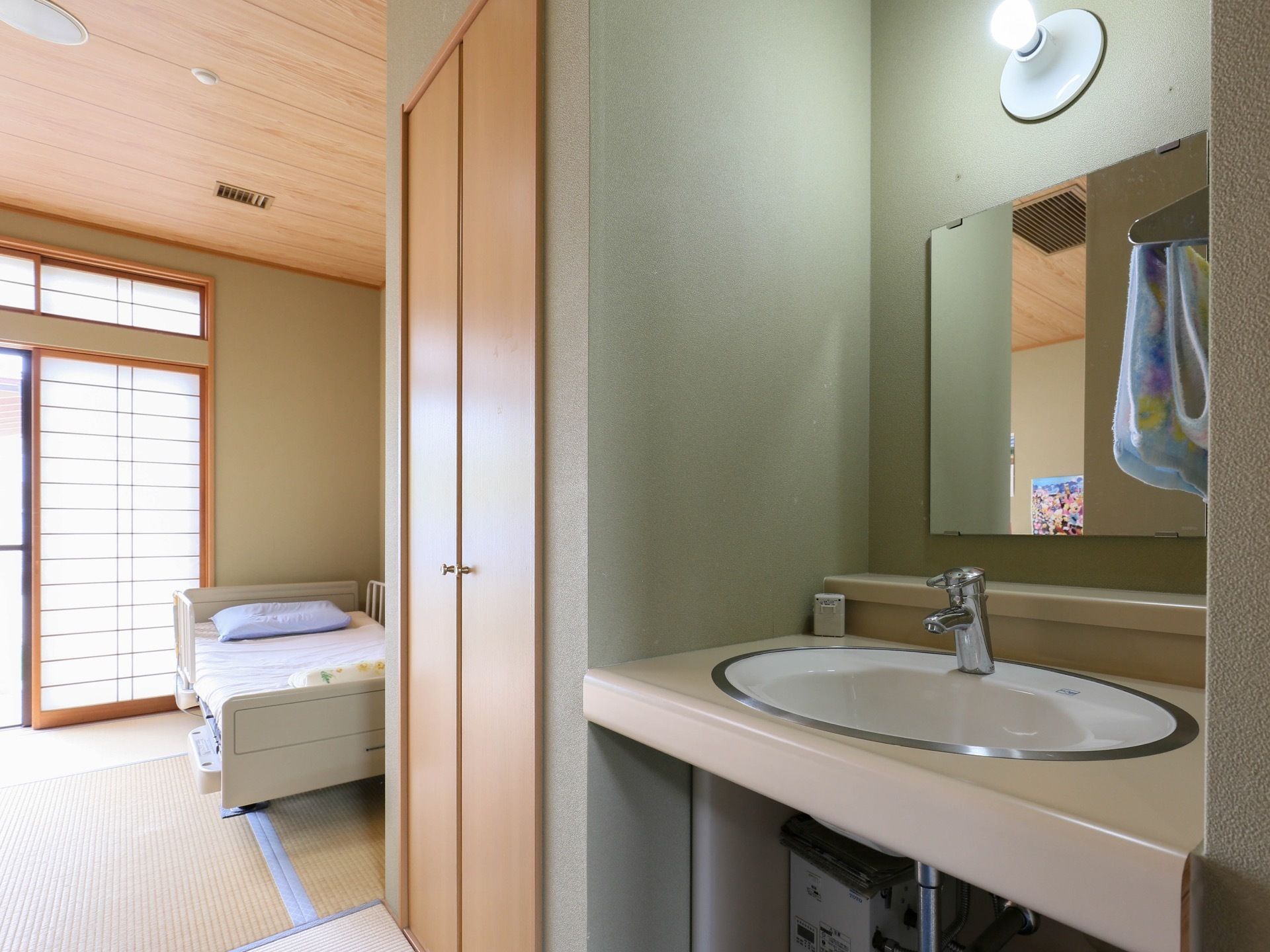 和室の畳敷きの部屋で、障子もある。畳の上にベッドが置かれている。備え付けのクローゼットがあり、洗面台もある。