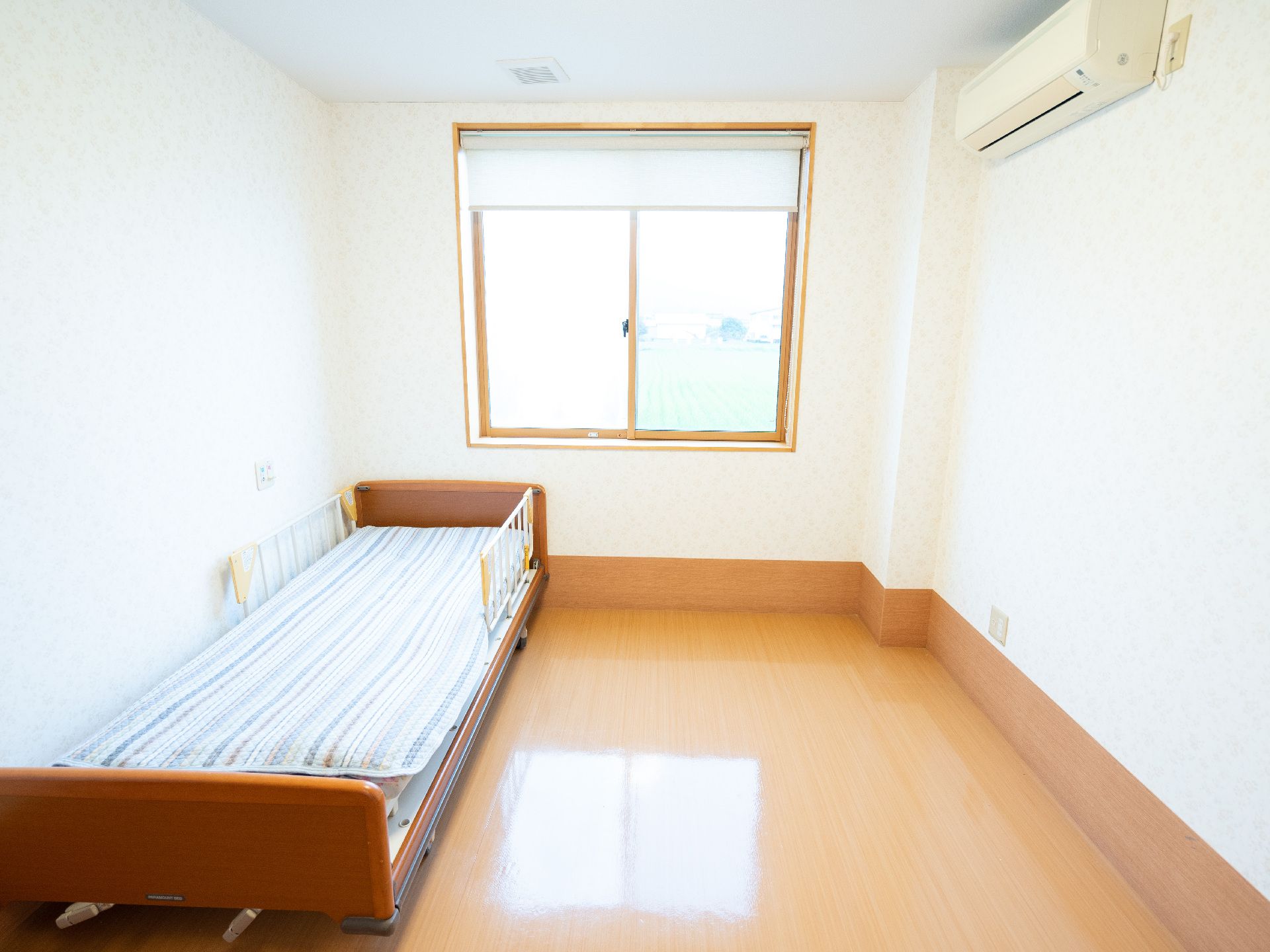 窓から日差しが注ぎ、介護ベッドなどが置かれている居室