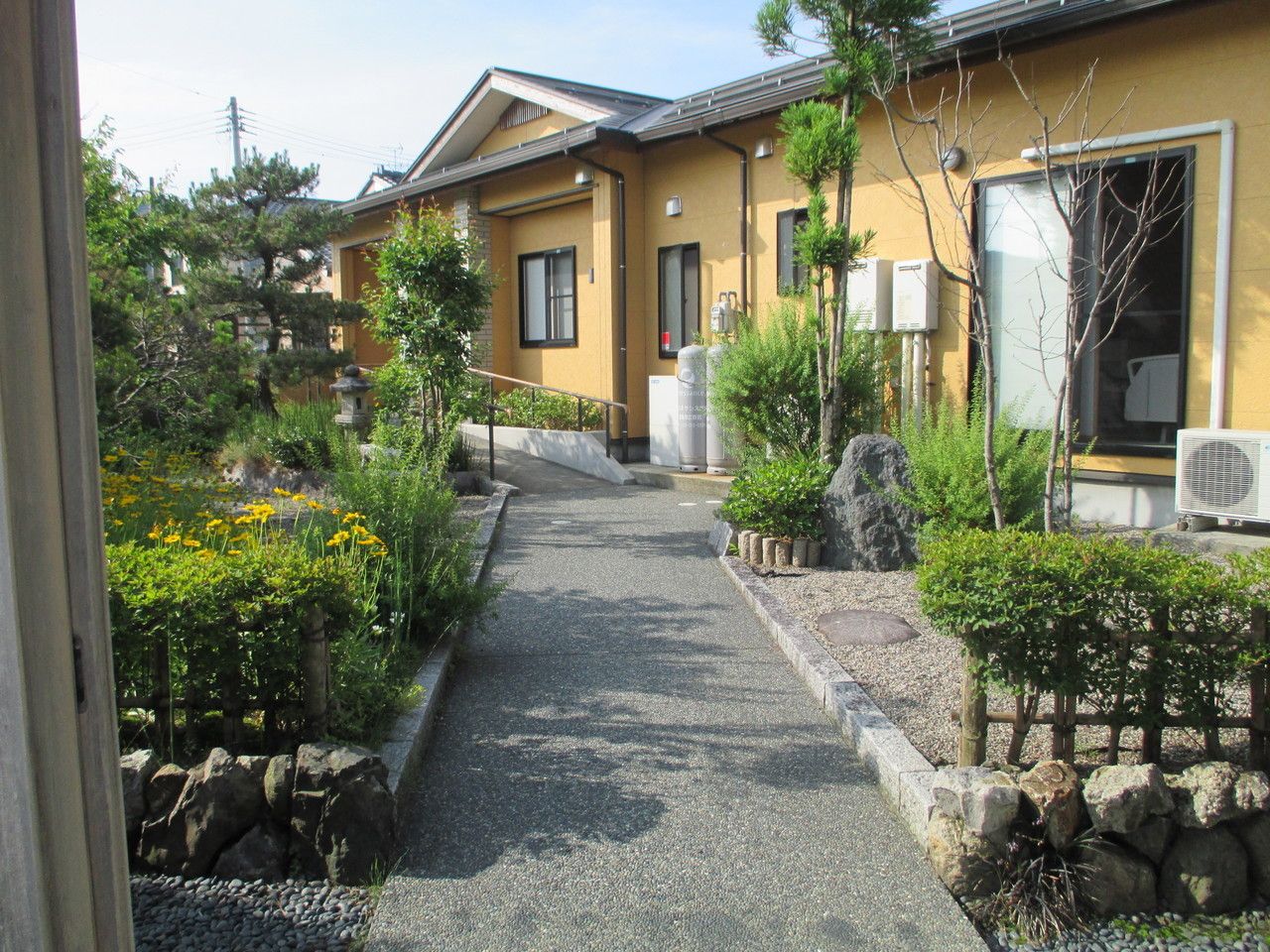 盆栽が並ぶ日本庭園のような中庭。遊歩道が真ん中に作られている様子