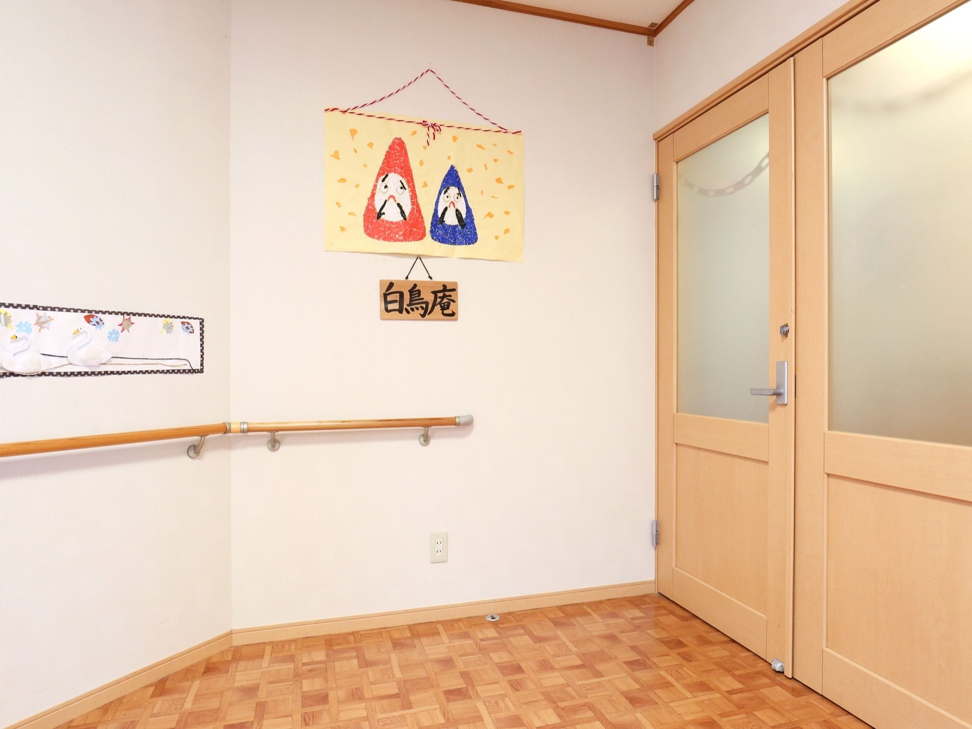 掴まりながら移動できるように、壁には手すりを設置している。扉の前は部屋の名前が分かるようにプレートを掛けている。