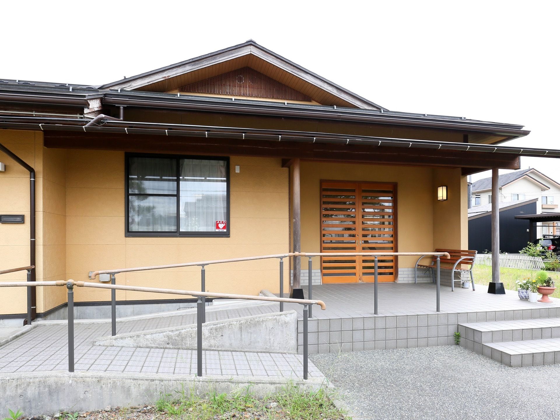 玄関へは、階段と手すり付きのスロープを使って移動することが可能。安全でストレスの少ない生活ができるように環境を整えている。