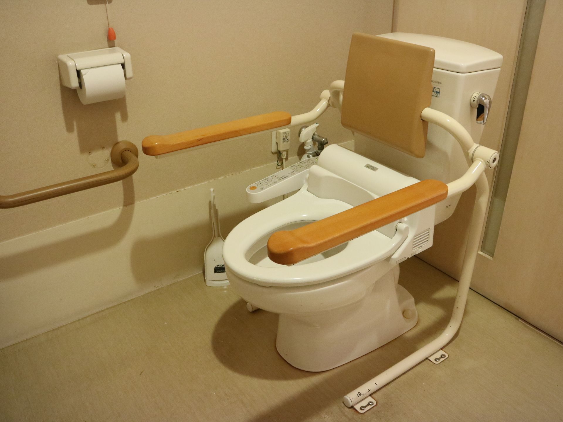 背中部分にクッションがあり左右に手すりが設置されたトイレ