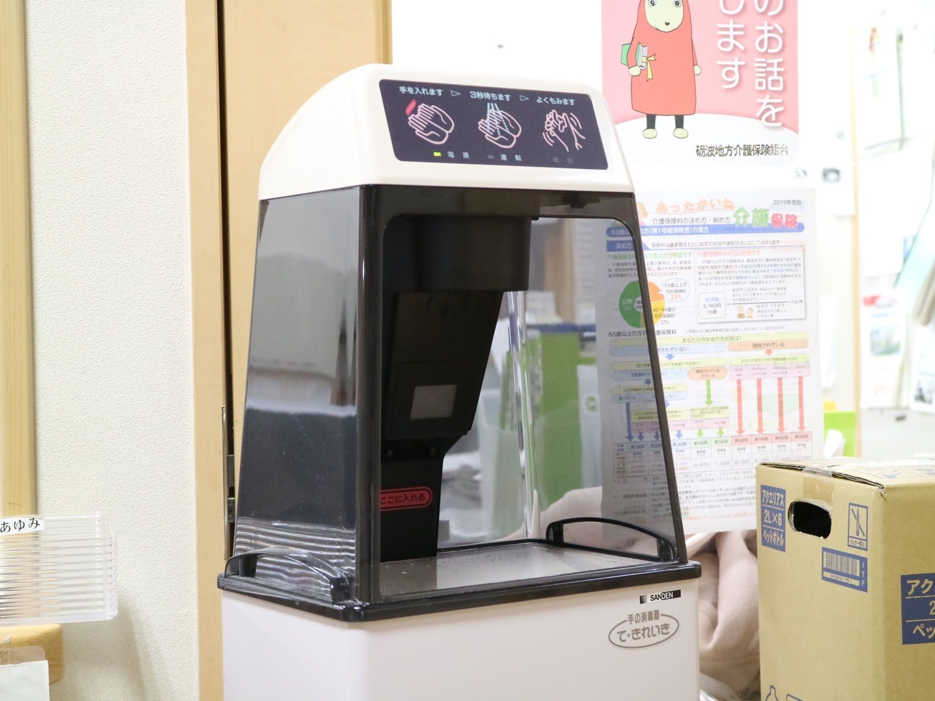 館内に置かれている手先の消毒機械である。黒い半透明のカバーで覆われた台形の機械で、手を入れる口が開いている。