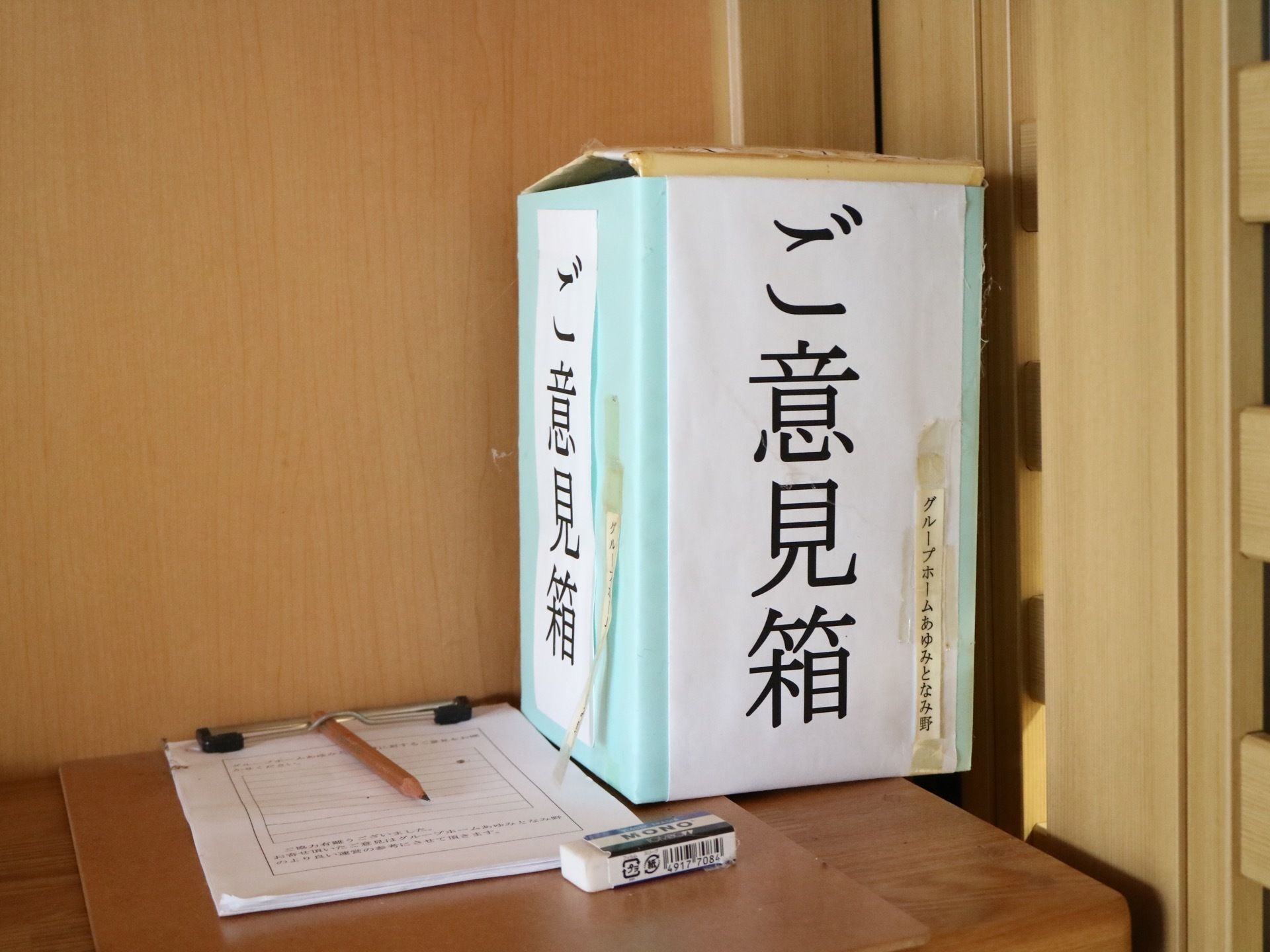 館内に設置されているご意見箱。木製の棚の上に手作りの大きな箱が置かれている。箱の前に専用用紙がある。