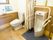 洋式便座、男性用の小便器が設置されたトイレである。グレーのマットが敷かれている。手すりも設けられている。