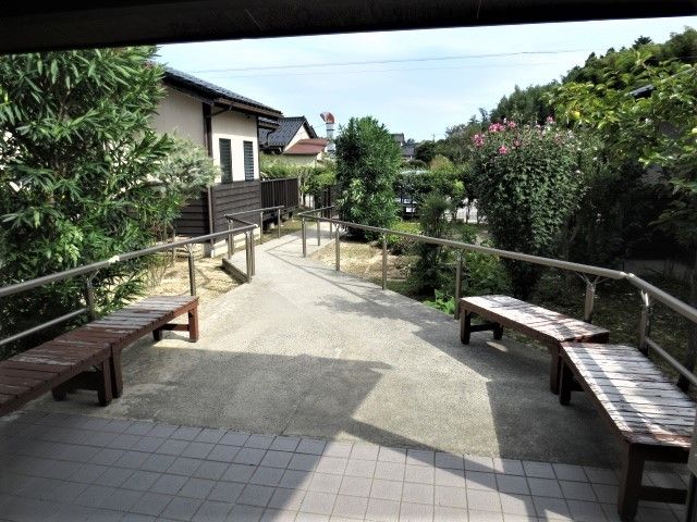 入口には木々が植えられている。入り口の左右にはベンチが置かれている。