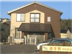 青空の下に建っている建物の写真。一軒家風のグループホームの外観