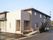 ２階建ての建物はブラウン系でまとめられ、玄関周りには手すり付きのスロープがある。