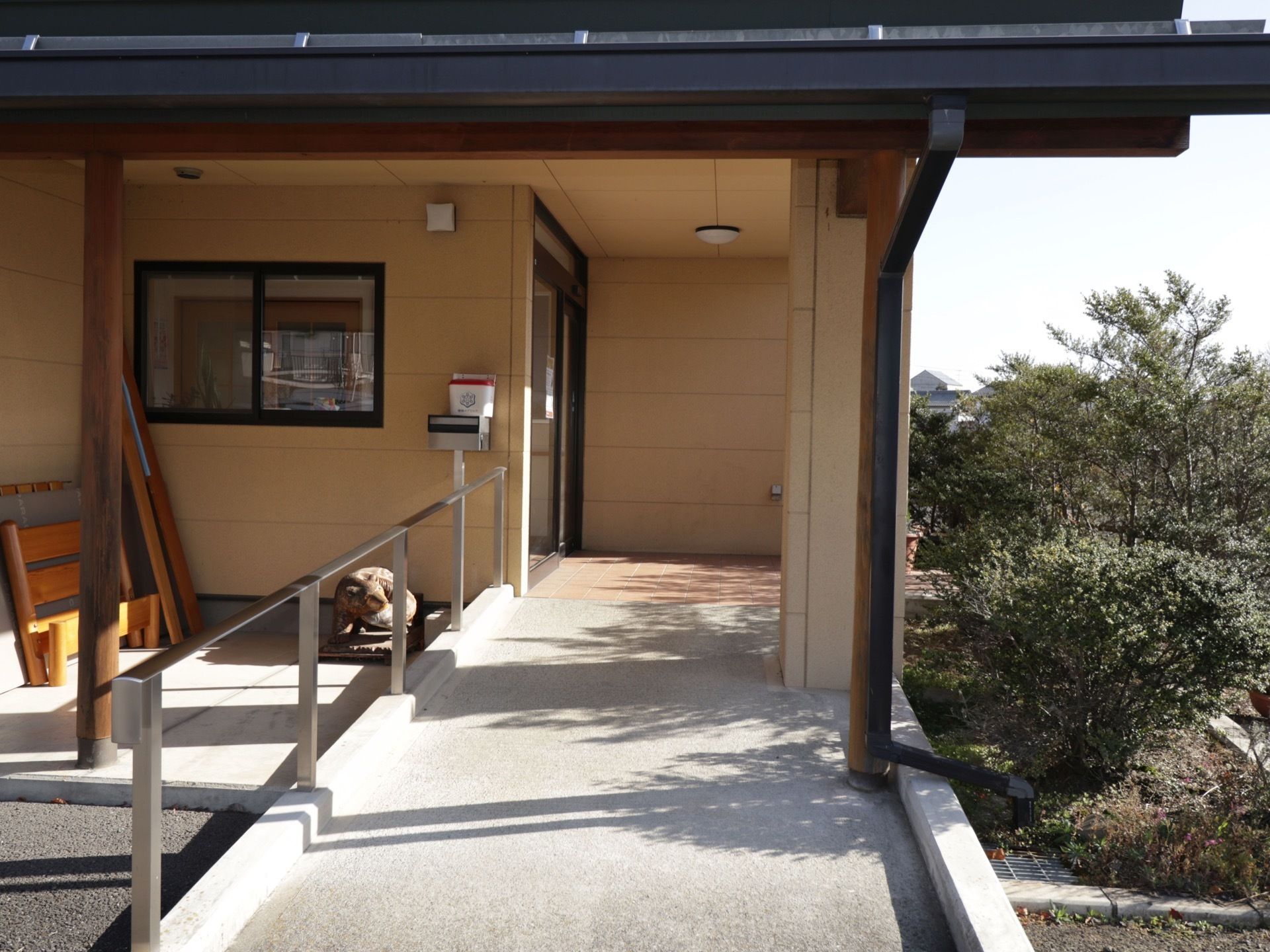 広々としたスロープになっており、片側に手すりが設置されている。大きく屋根がせり出しており、傘の準備をゆったり行うことができる。