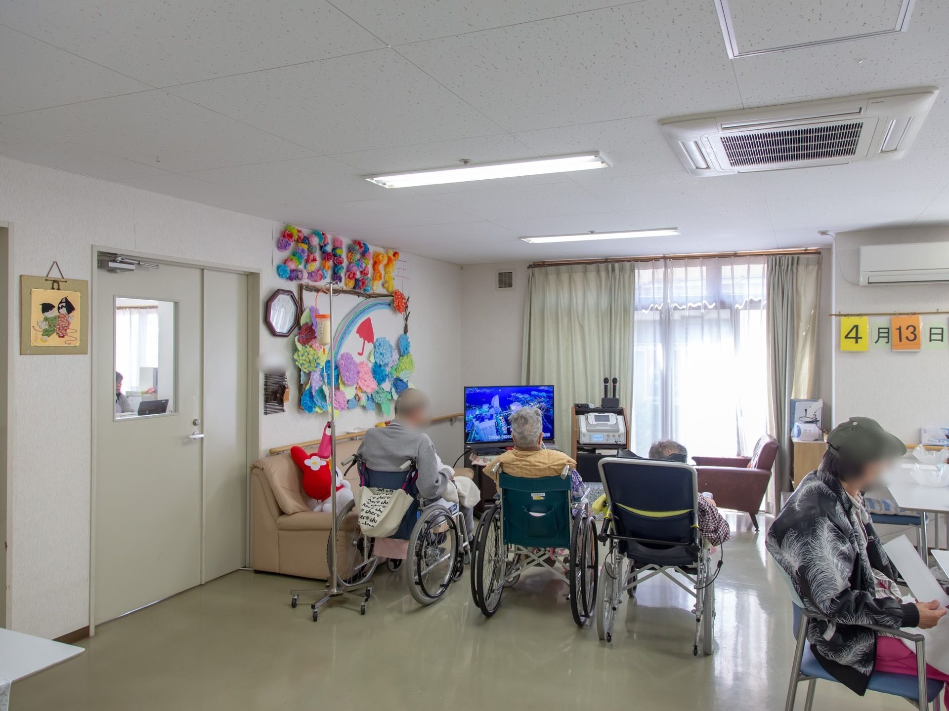 ホールの壁には季節を感じる手作りの作品が飾ってある。テレビを見たり、テーブルで好きなことをしたりして楽しく過ごせる。