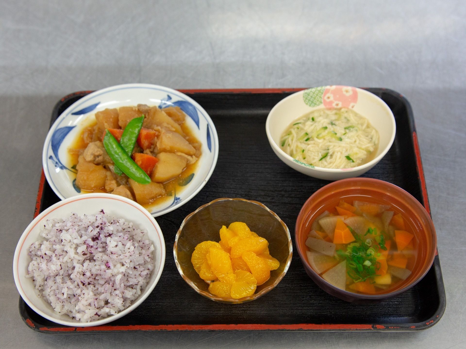 トレイの上にご飯・みそ汁・漬物・おかず2種がのっている。野菜がたくさんとれて、栄養価を考えた食事になっている。