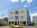 3階建ての施設の外壁は落ち着いたグレー系の色合いである。正面には緑があり目を和ませている。周りは車が出入りしやすいスペースがある。