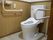 個室トイレの一例である。中央に温水洗浄便座が取り付けられたトイレがあり、便座の両側に手すりがある。