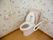 トイレには花柄の壁紙が使われている。便器の周りには手すりが用意されている。床はフローリングになっている。