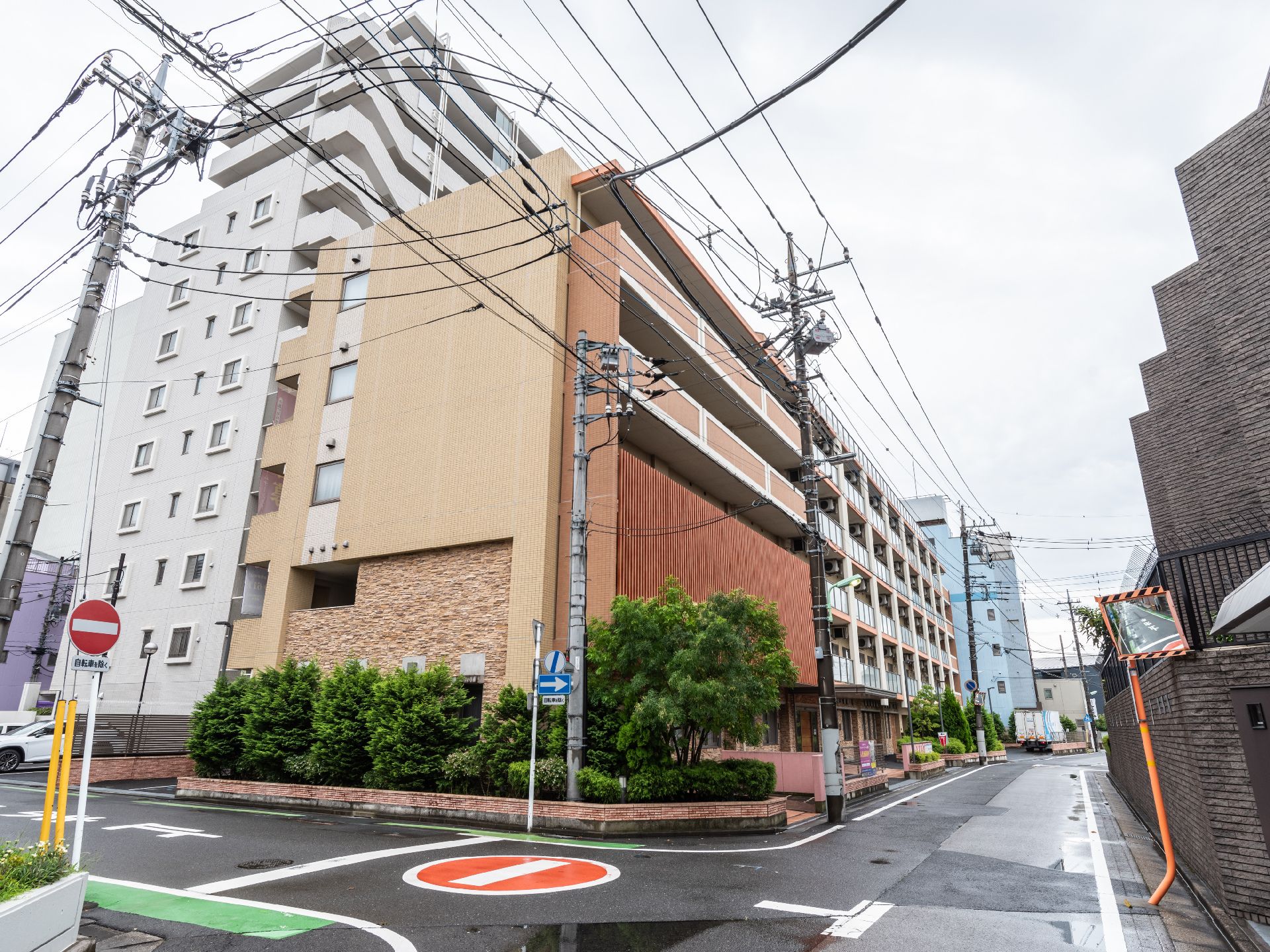 アスファルトの道路沿いに立地しているベージュ系の外観で６階建ての建物