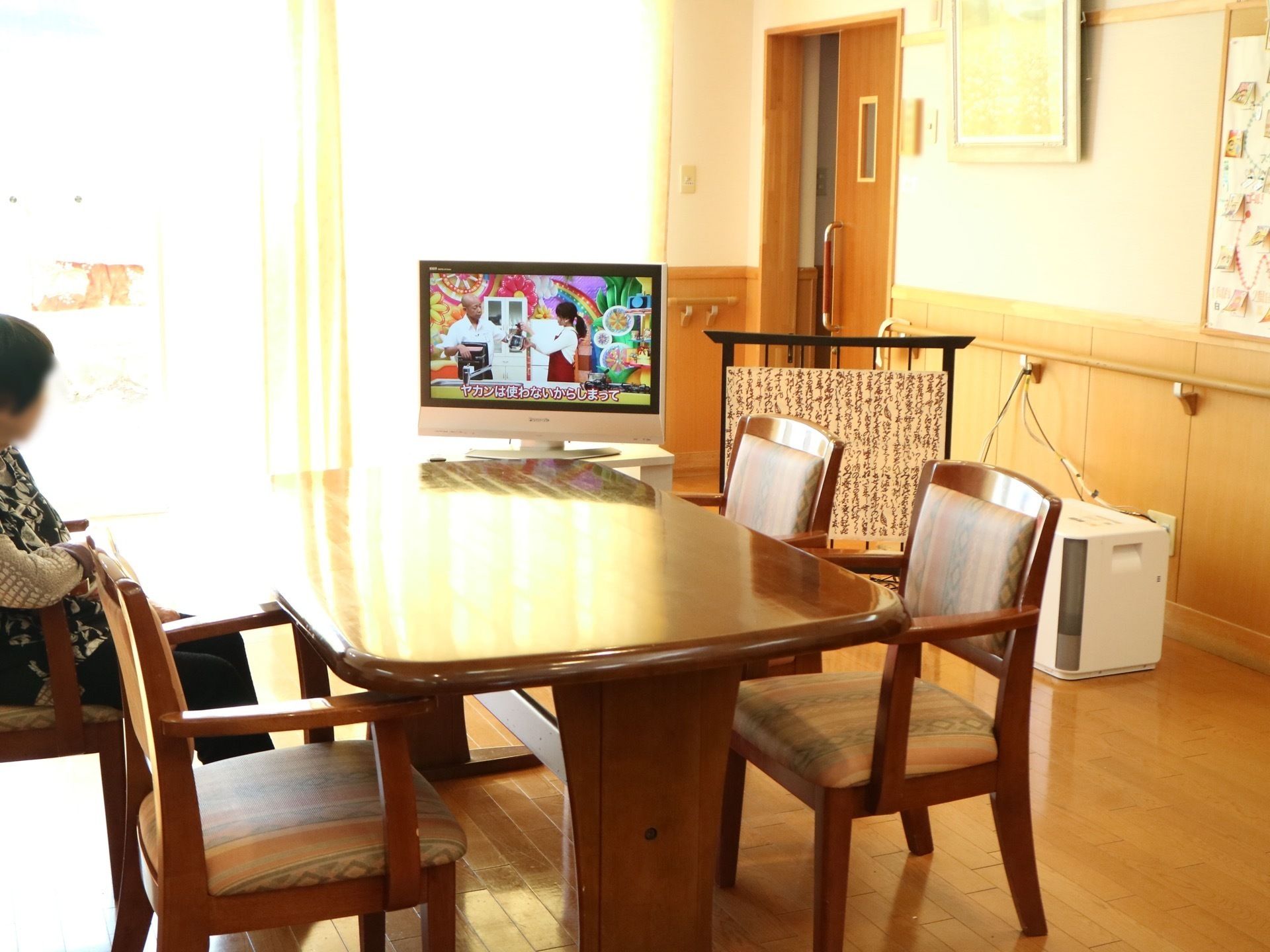 ダイニングルームでテレビを見ている老人ホームの入居者