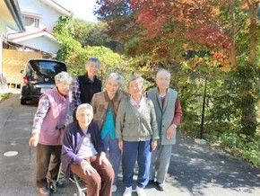 屋外にて笑顔で記念撮影に応じる入居者6名。