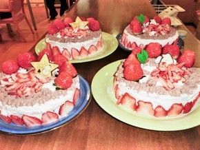 イチゴがたくさん載ったクリスマスケーキが4ホール、テーブルに置かれている。
