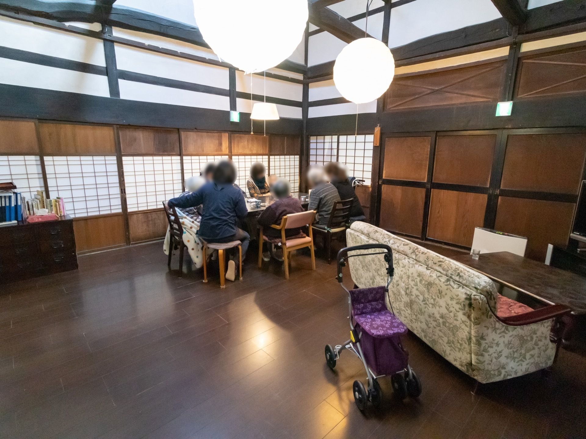 モダンな雰囲気の共有スペースに集まる介護施設の入居者