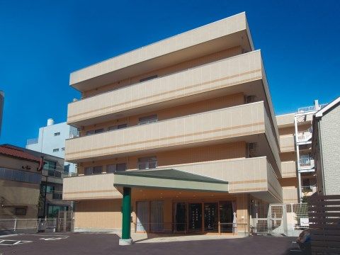 玄関前に大きく張り出した、緑色の屋根がついた車寄せ