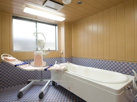 ブルーと白の格子状になったタイルが貼られており、壁半分と天井は木目調になっている。寝たままの姿勢で入浴できる浴槽が設置されている。