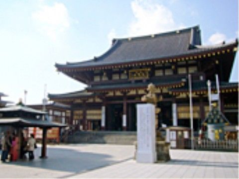 大きな神社があり、前は階段になっている。本堂の手前の献香所にて煙を浴びるところがあり、人が数人いる。近くには灯ろうなどがある。