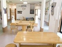 木製のダイニングテーブルが２組置かれ、ぬくもりが感じられる食堂。