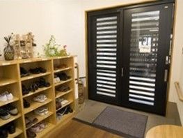玄関先には大きめの靴箱が置かれ、靴箱の上には小物が飾られている。