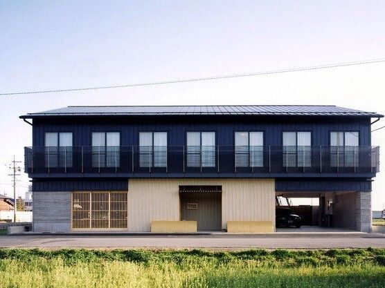 ２階建ての建物は日当たり良好で三角屋根が付き、建物の前には畑がある。